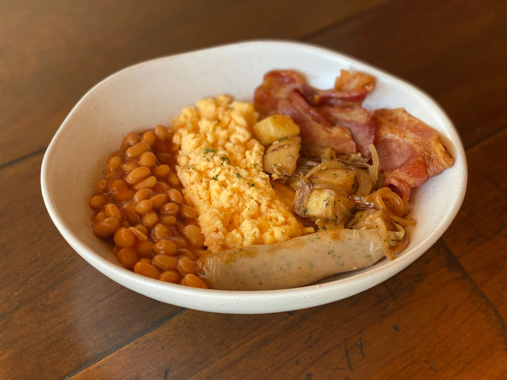 bowl with an all day breakfast including beans eggs potato bacon and sausage