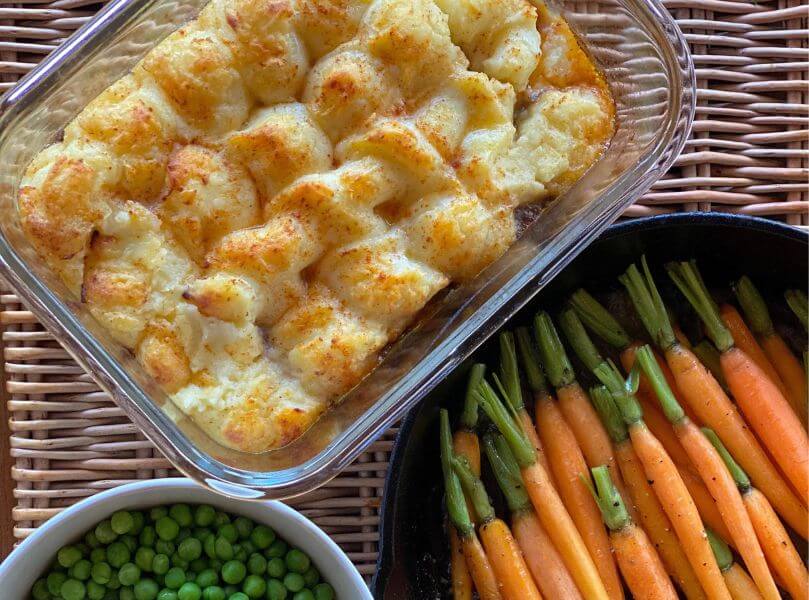 flat lay of cottage pie steamed carrots and peas by dinners ready