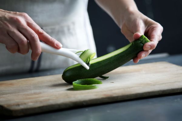 a chef peeling a fresh cucumber