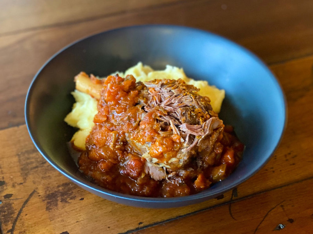 bowl with tender cooked lamb shank with mash potato